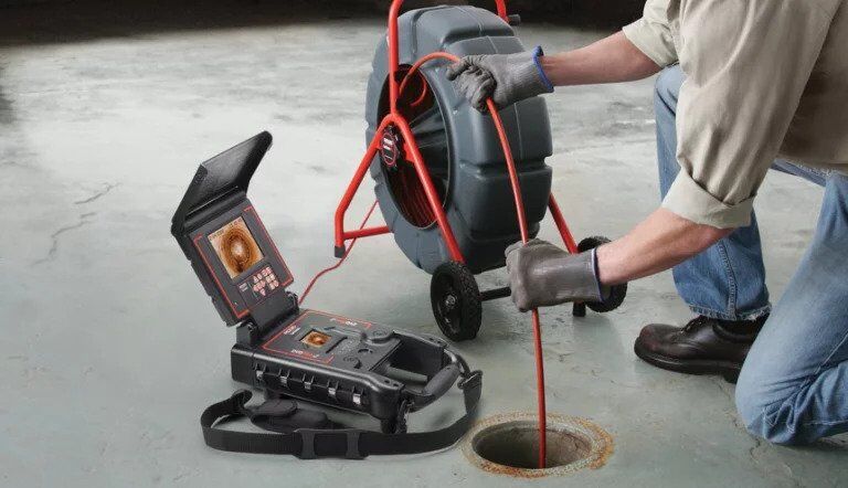 plumber inspecting sewer line camera inspection